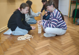Uśmiechnięte uczennice klasy V grają w ,,JENGĘ"