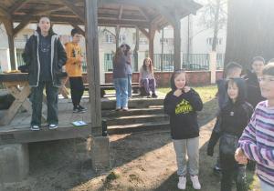 Radośni uczniowie z klasy V spędzają czas w szkolnym ogrodzie: na rozmowach