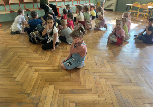 Spotkanie przedszkolaków z przyszłą Panią wychowawczynią. Dzieci siedzą przez Panią i z zaciekawieniem słuchają co Pani chce przekazać.