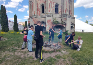 Na polu przy Twierdzy dzieci mają rozpalone ognisko i stoją przy nim i pieką kiełaski.