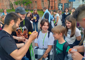 Organizator gry terenowej ,,Enigma" wręcza medale zwycięskiej drużynie.y