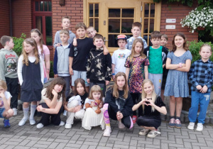 Uczniowie klas II i III z uśmiechniętymi minami pozują do zdjęcia przed wejście do dyskoteki, która znajduje się na terenie Ośrodka Konnego w Hermanowie.