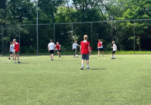 Uczniowie rozgrywają akcje po środku boiska. Przy piłce jeden zawodnik, reszta ustawia się tak aby miał komu podać a przeciwna drużyna , tak aby przejąć piłkę.