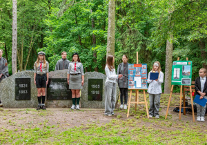 Uczennice naszej szkoły przy pomniku rewolucjonistów przedstawiają projekt, który był realizowany w szkole.