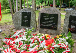 Pomnik rewolucjonistów obłożony kwiatami.