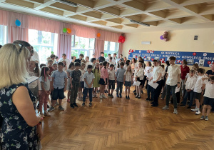 Spotkanie na korytarzu drugiego piętra wszystkich uczniów i nauczycieli z okazji Dnia Patrona Szkoły. Wspólny śpiew ,,Prząszniczki"