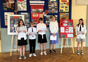 Uczniowie klasy V przedstawiają projekt, za który byli odpowiedzialni. Stoją przy wykonanym przez siebie plakacie