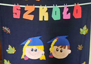 Kolorowy, jesienny plakat ,,Witaj Szkoło", twarze dzieciaków w czapeczkach.