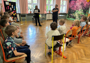 Zajęcia ze Strażą Miejską. Dzieci z klasy trzeciej uważnie słuchają Pań strażniczek.