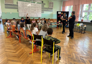 Zajęcia ze Strażą Miejską. Dzieci z klasy trzeciej uważnie słuchają Pań strażniczek.