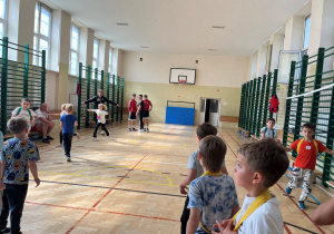 Zawodnik ŁKs prowadzi rozgrzewkę dla naszych najmlodzych uczniów. Wszyscy wykonują ćwiczenia z precyzją i zaangażowaniem.