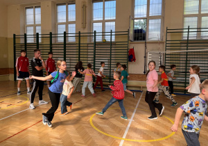 Trener obserwuje naszych uczniów podczas rozgrzewki. Dzieci z zadowoleniem wykonują zadane ćwiczenia.