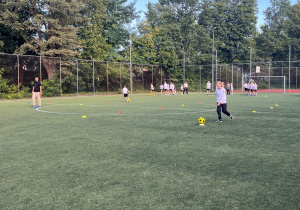 Kolejna konkurencja, uczniowie slalomem prowadzą piłkę do nogi, oczywiście do wyznaczonego miejsca.