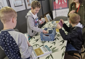 Uczniowie ,,pod okiem" pani prowadzącej szykują sie do tkania. Szykują sobie materiały.