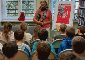 Nasi uczniowie na spotkaniu z panią Ewą Chotomską. Dzieci słuchają z uwagą o jej twórczości i życiu