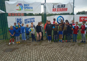 Srebrna drużyna z SP40. Uczniowie stoją przy banerach Aktywna Szkoła, Orły Sportu, Z Orlika na stadion.