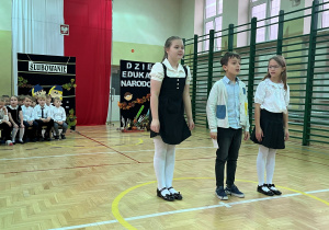 Występ uczniów klasy drugiej i trzeciej dla pracowników naszej szkoły. Dwie uczennice i uczeń mówią wierszyki dla wszystkich pracowników naszej szkoły