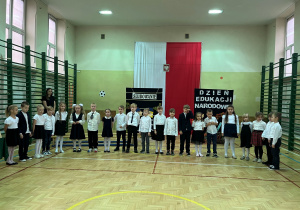 Część artystyczna uczniów klasy pierwszej, uczniowie ustawieniu w półkolu mówią wierszyki o szkole.