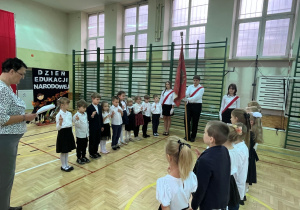 Uczniowie klasy pierwszej ustawieni przy Sztandarze Szkoły, składają oficjalne ślubowanie trzymając dwa paluszki w górze