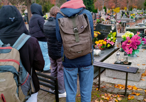 Klasa VI pod pomnikiem Rewolucjonistów na Cmentarzu Mania zapalają znicz.