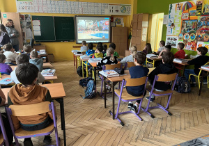 Uczniowie podczas warsztatów obserwują emocje podczas tańca na filmach przedstawionych przez prowadzące warsztaty