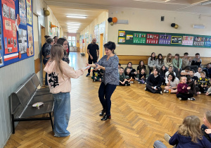 Pani pedagog i nauczyciel wspierający ucznia odbiera karteczkę z życzeniami.