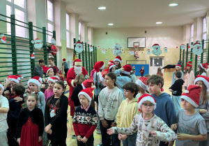 Uczniowie bawią się i pomagają śpiewać klasom, które właśnie występują dla Mikołaja.