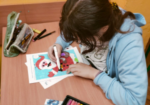 Uczennica rozwiązujący matematyczne karty pracy