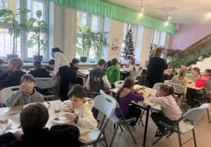 Grupa półkolonijna przebywa na stołówce szkolnej i wspólnie spożywa śniadanie. To pierwsze śniadanie naszych półkolonistów.