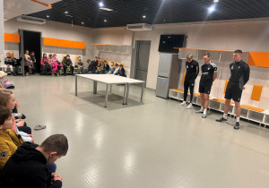 Stadion ŁKS, w szatni piłkarzy gości - oczekiwali na nas piłkarze pierwszej drużyny ŁKS- uczestnicy mogli ich pytać o ich kariery, marzenia oraz plany. Piłkarze stoją na środku, dzieci siedzą wokoło nich