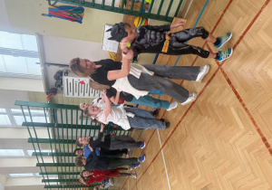 Sala gimnastyczna, pani wychowawczyni bawi się z dziećmi(dzieci w strojach karnawałowych), chłopcy i dziewczęta utworzyli pociąg