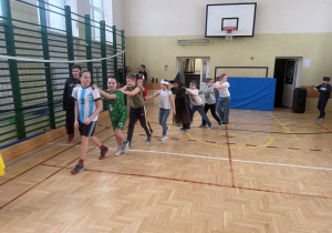 Sala gimnastyczna, chłopcy i dziewczęta bawią się w rytm muzyki, utworzyli pociąg.