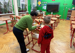 W pracowni ekologicznej p. Mariola od przyrody pokazuje przyszłemu pierwszoklasiście płytkę krwi pod mikroskopem.