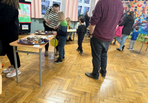 Słodki kącik dla naszych przyszłych uczniów. Na stoliku są upieczone babeczki przez naszych uczniów, a dziecko wraz z rodzicem częstują się łakociami