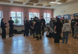 Uczniowie szkoły ,,Oświatowiec" pokazują naszym uczniom klasy VIII jak należy pomóc poszkodowanemu
