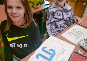 Uczniowie klasy 4 dumnie prezentują w zeszytach matematycznych własnoręcznie wykonane, zakodowane symbole liczby Pi (zakodowany symbol π), wykorzystując technikę pixel art w ramach obchodów Dnia Liczby Pi.