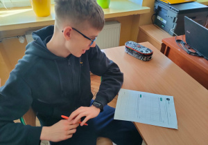 Uczeń klasy VIII rozwiązuje wielkanocne zadania matematyczne.