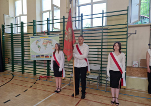 Sala gimnatyczna,wprowadzenie sztandaru szkoły. Trzech ucznów z klasy ósmej