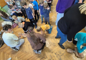 Uczniowie szkoły zgromadzeni na korytarzu, dzieci wykonująRKO