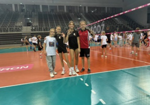 Hala Sport Arena nasze uczennice klasy VI pozują do zdjęcia na tle boiska do siatkówki