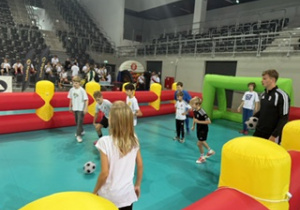 Hala Sport Arena, nasi uczniowie grają w piłkę nożną z piłkarzem ŁKS na dmuchanym boiski